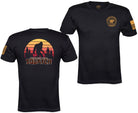 Two views of a black short-sleeve t-shirt on a white background. The left view shows a large back graphic with a silhouette of Bigfoot against a sunset gradient and the text 'IN THE LAND OF SQUATCHES'.