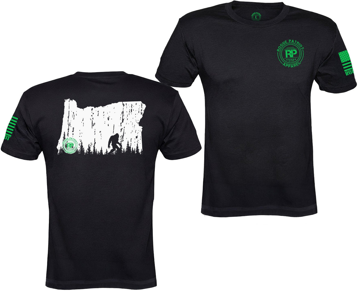 Two black short-sleeve t-shirts shown on a plain white background, with the front and back views side by side. The front shirt has a green circular chest logo reading 'Rustico Products' with 'RP' inside.